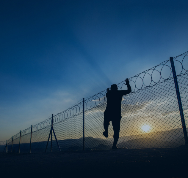 Man climbing over fence