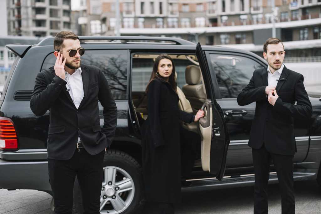 Women exiting dark car with VIP Protection and Body Guards